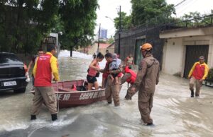 Bombeiros usam bote para salvar vidas durante chuva forte, em Manaus