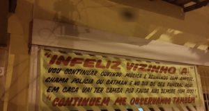 Moradora coloca faixa na porta de casa e avisa que continuará dando festas“Infeliz vizinho (a), vou continuar ouvindo música e reunindo com amigos. Chama polícia ou Batman”, desafia a moradora